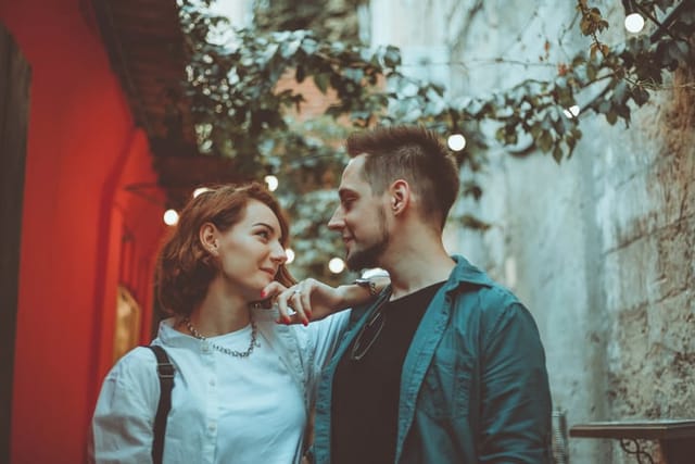 couple smiling at one another in alley