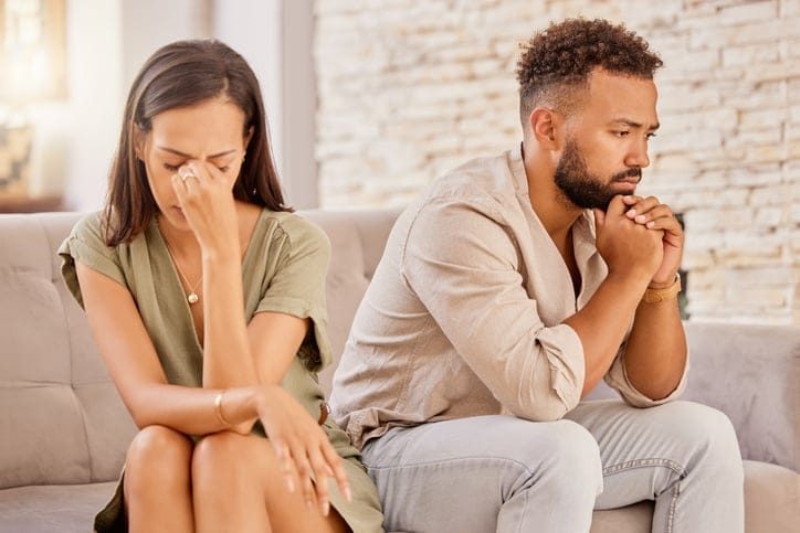 Unhappy couple sitting on couch.