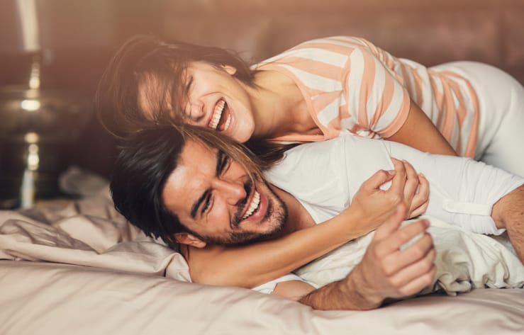 Happy young couple in bed