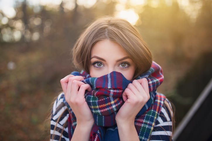 Woman covering face with scarf.