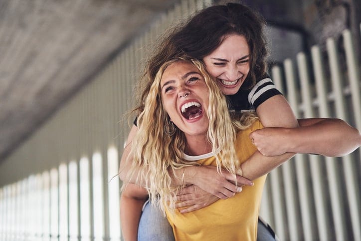 Laughing girlfriends having fun together in the city at night.