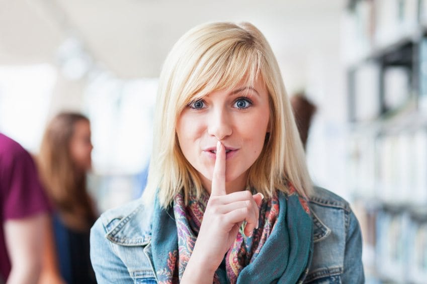 blonde woman doing shush motion