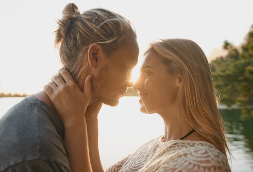 romantic couple embracing by lake
