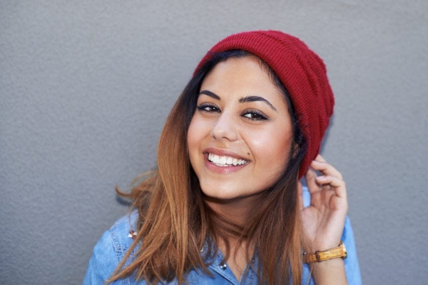 hip woman in red beanie smiling