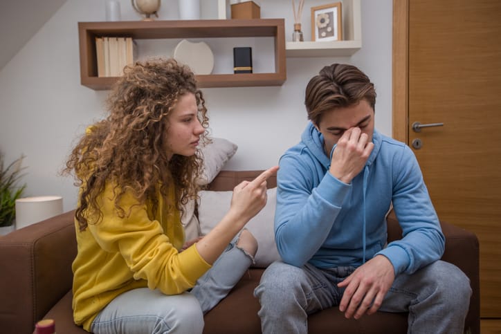 young couple arguing on couch