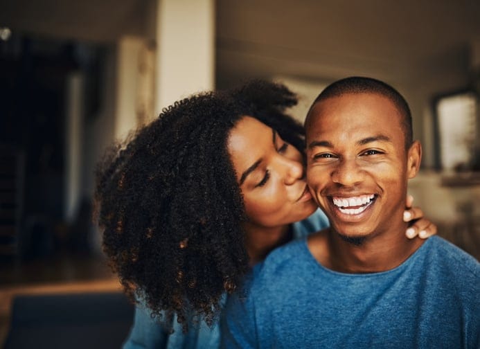 happy girlfriend kissing boyfriend's cheek