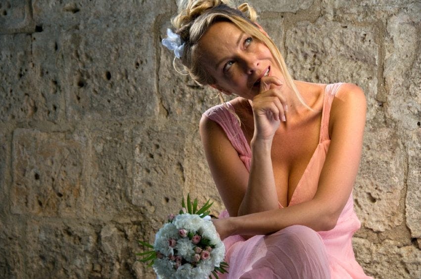 Pensive woman in pink bridesmaid dress