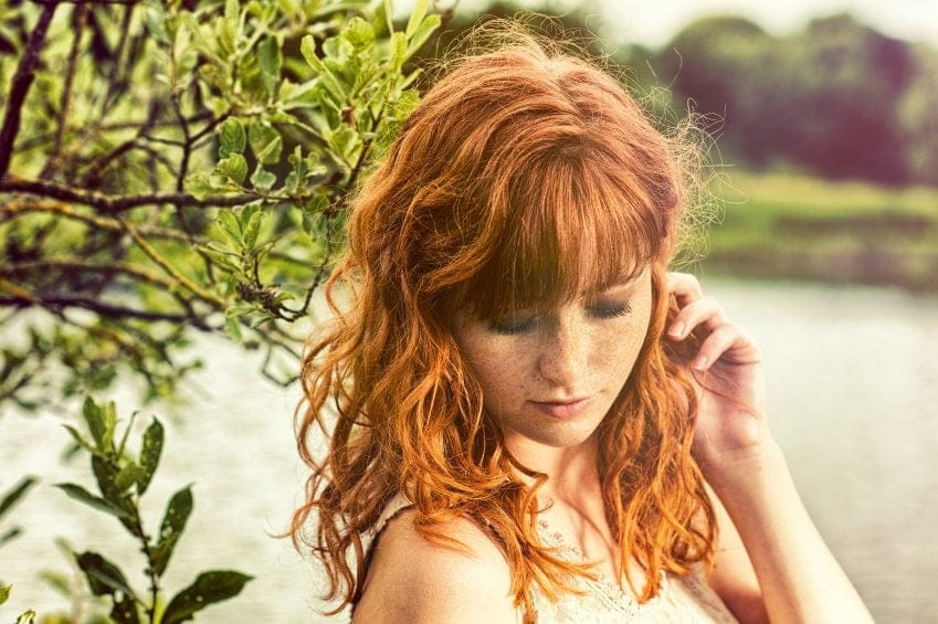 Ginger girl with freckles on beach