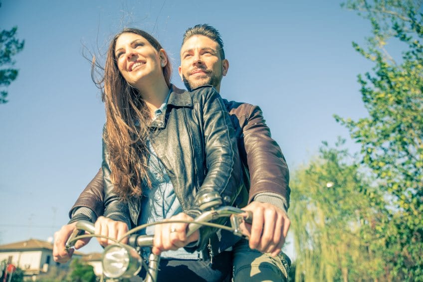 Couple riding on bikes on sunny day