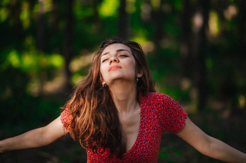 Brunette woman meditating in forest