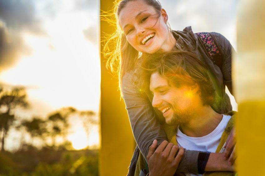 Couple on hike smiling while resting