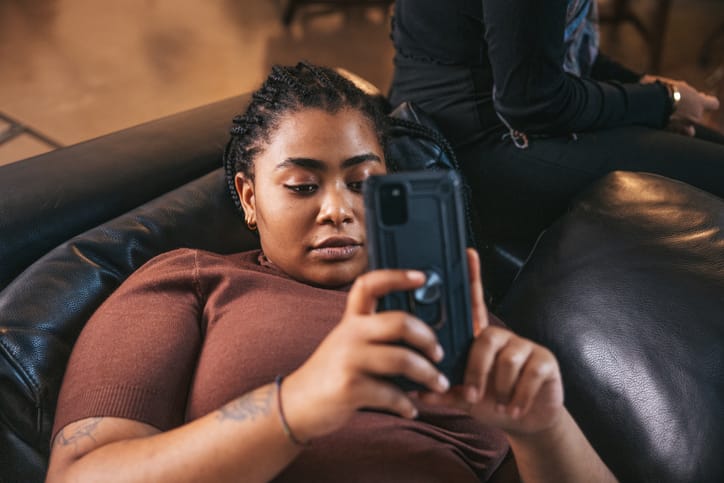 teen girl texting on couch
