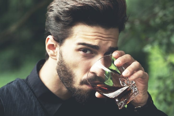 Bearded man with glass of whiskey