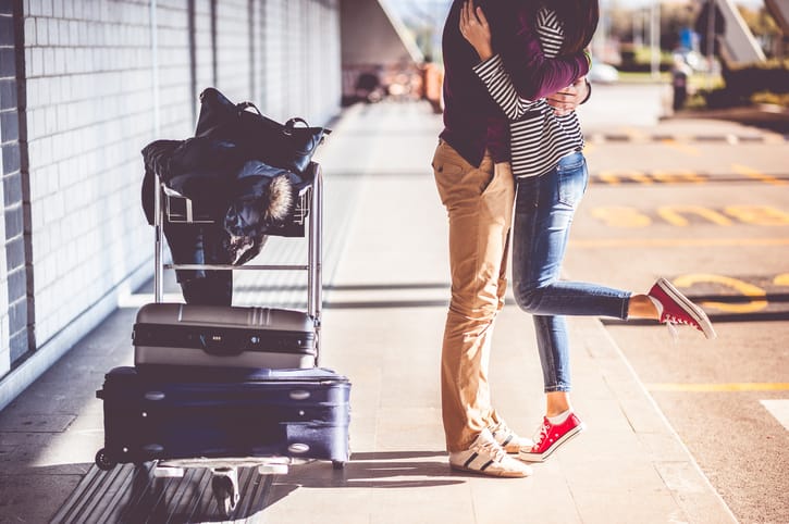 Couple kissing at the airport.