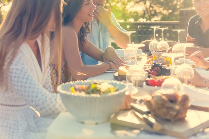 Group of young people eating outdoors.
