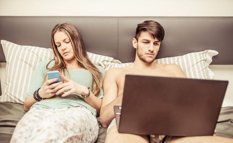 Couple in bed and technology