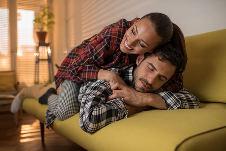 Young loving couple relaxing on sofa in the living room.
