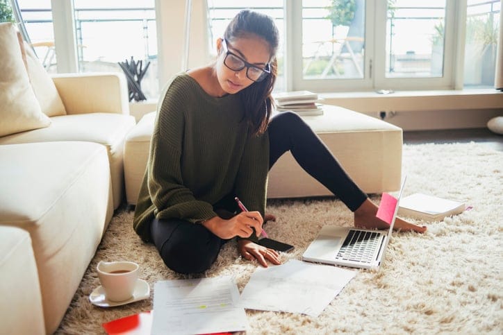 Young Gen Z woman studying and writing in a notebook