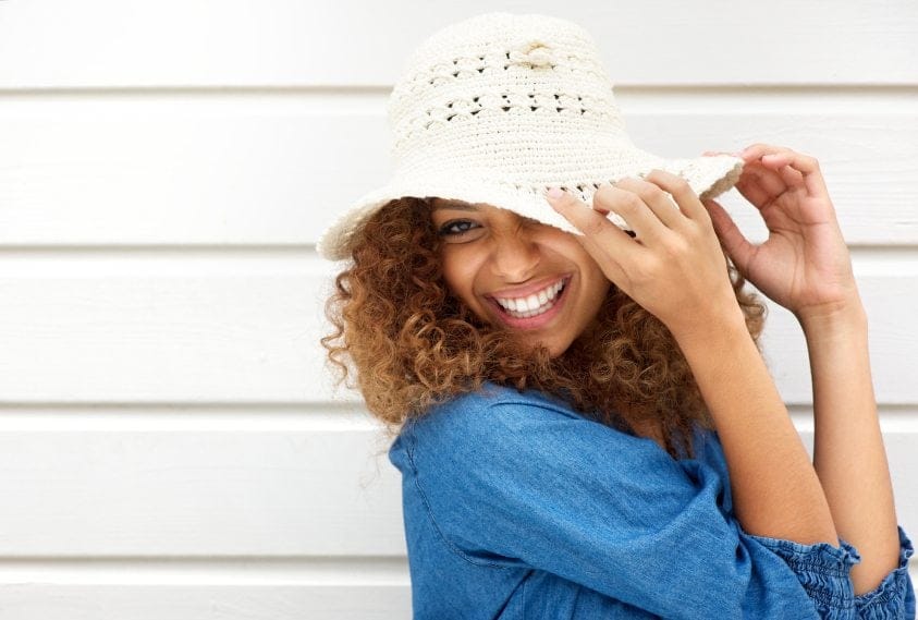 Portrait of a happy young woman wearing hat