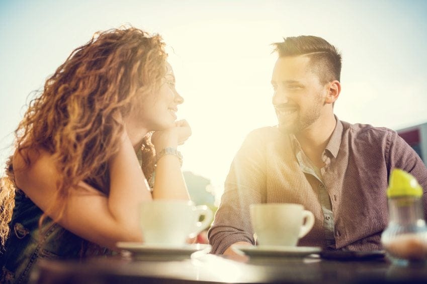 Couple talking to each other in a cafe at sunset