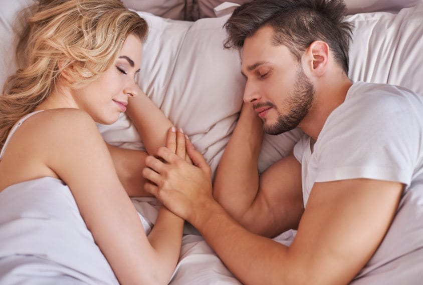 Couple facing each other in bed asleep