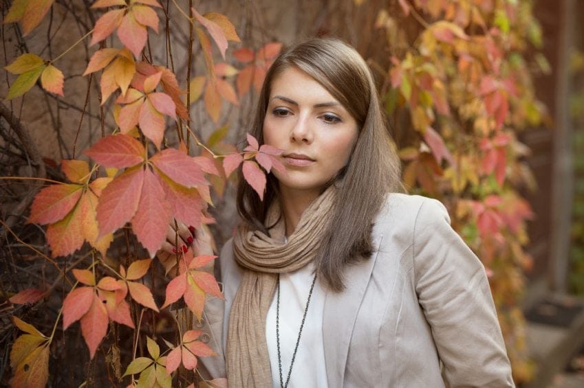 Brunette woman amongst autumn leaves