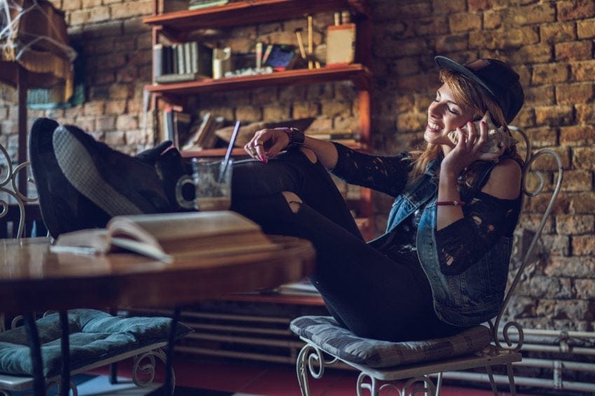 Young hipster woman enjoying in a sound from seashell