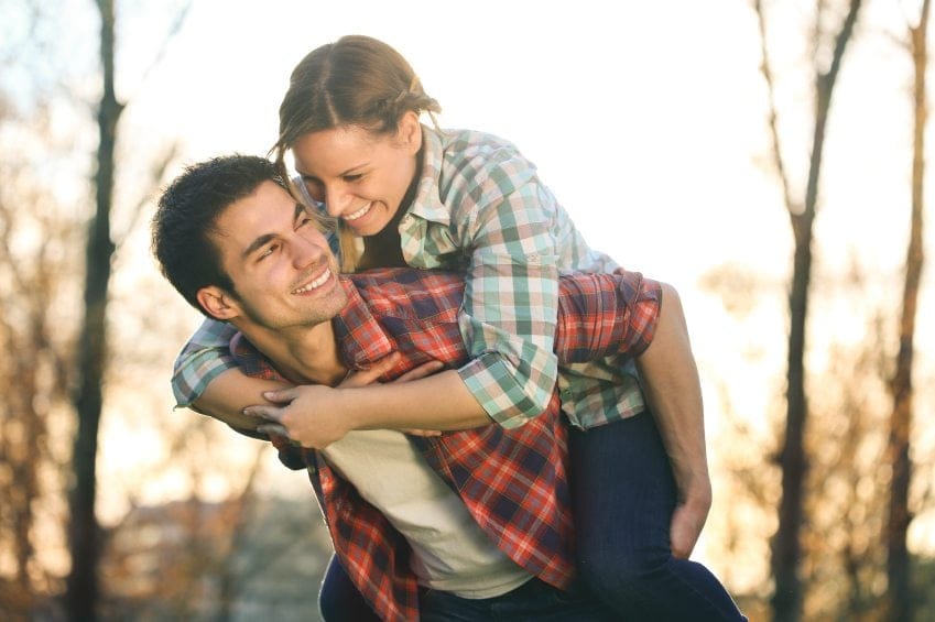 Happy couple giving piggy back