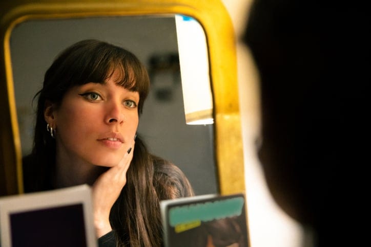 woman looking at herself in mirror