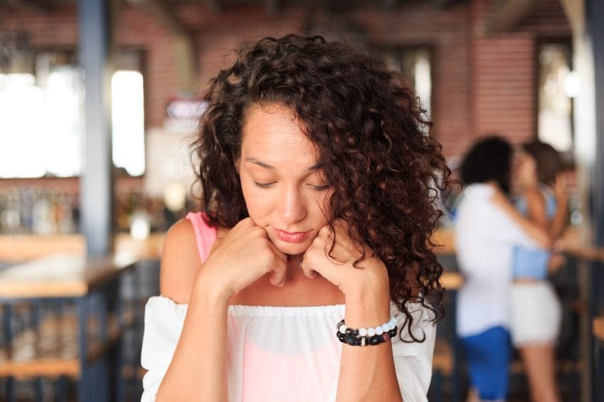 Curly haired woman sitting sad