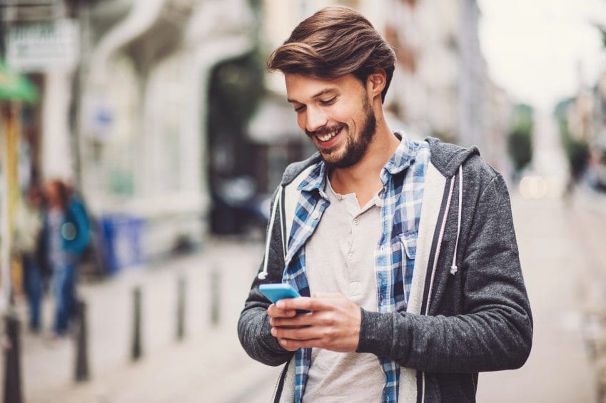 Guy texting walking in street