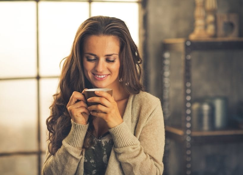 Smiling young woman with cup of coffee
