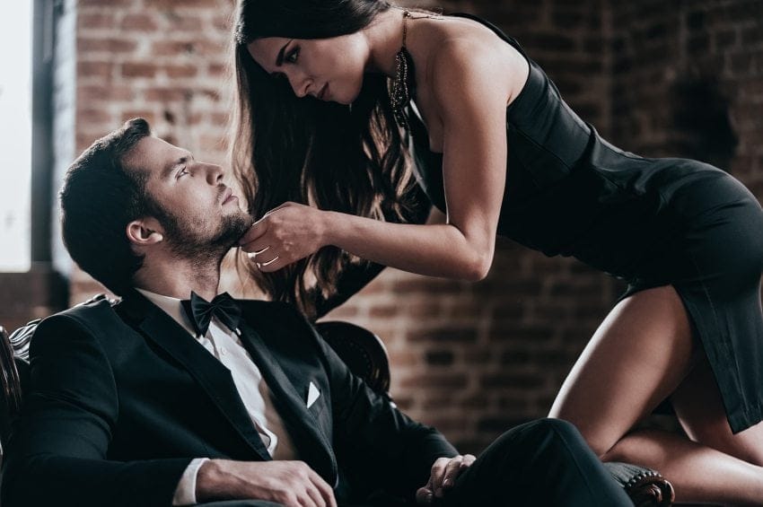Man in suit woman in dress flirting