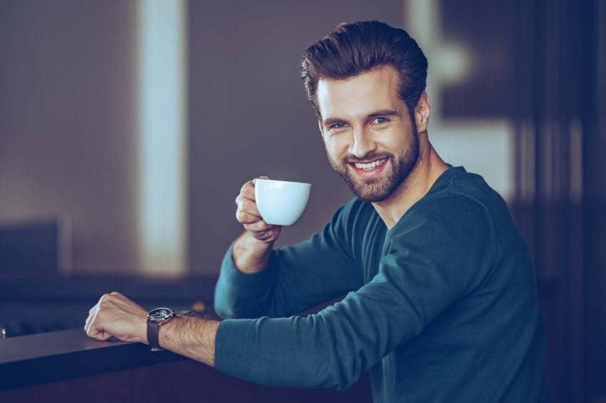 Handsome young man with beard and coffee cup