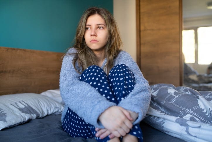 sad woman sitting in bed