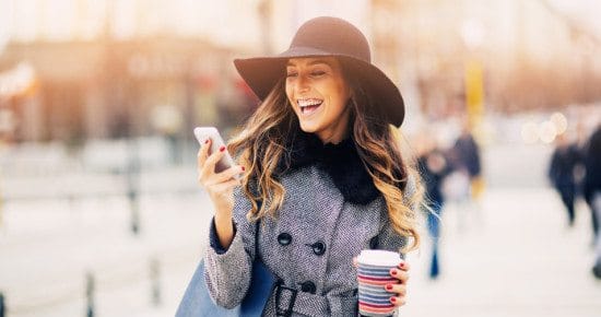 happy woman with coffee on phone