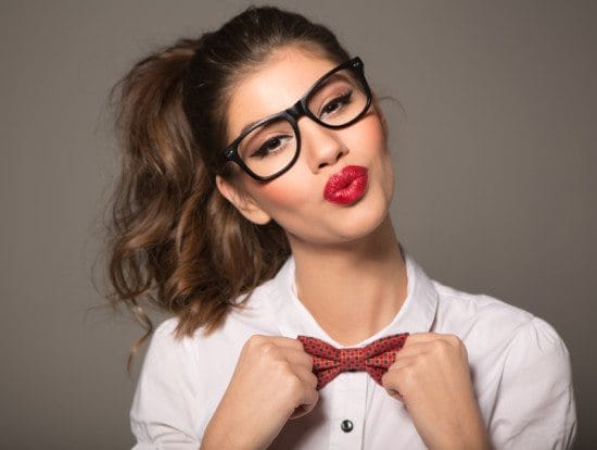 woman blowing kiss in glasses and bowtie