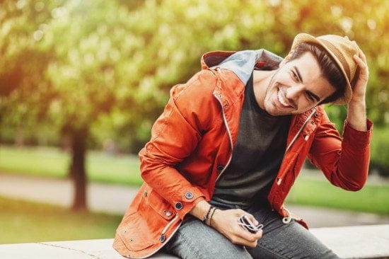 smiling man with hat in park