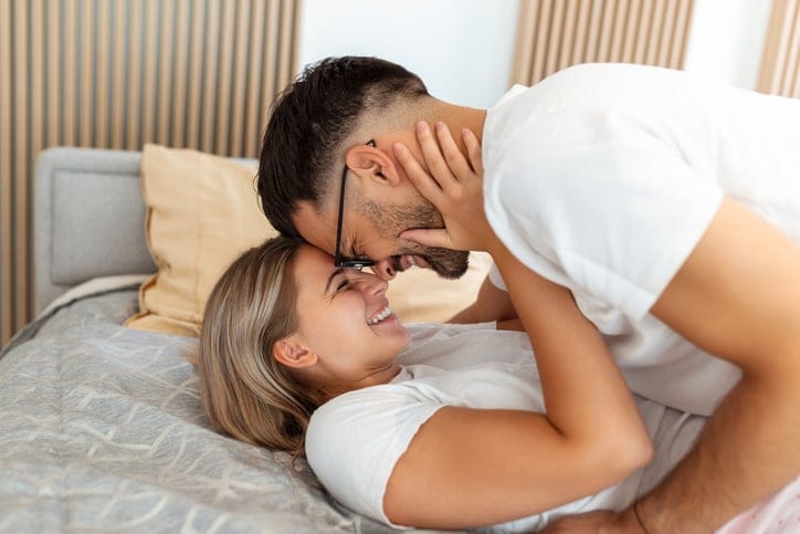 smiling couple getting intimate in bed