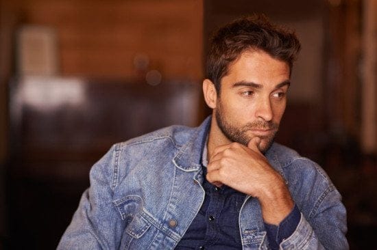 man looking pensive in denim jacket