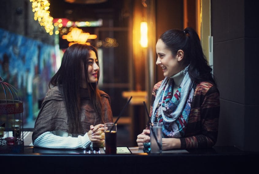 female friends drinking at nighttime bar