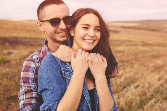 couple embracing in field of wheat