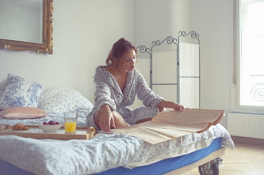 woman reading papers bed