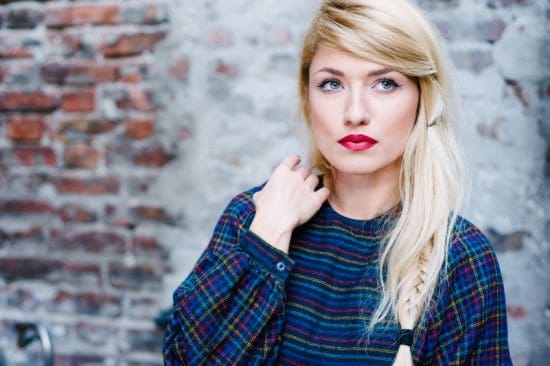 serious woman in plaid dress by wall