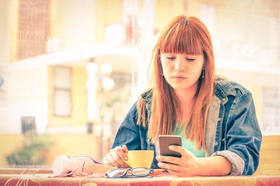 sad girl texting at cafe