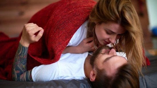 couple kissing under blanket