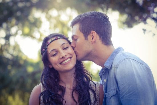 man kissing woman's cheek