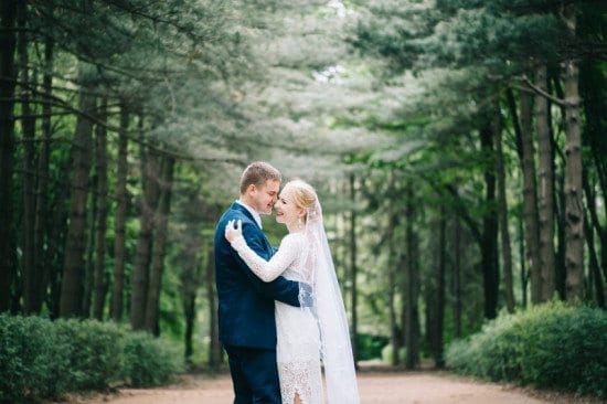 married couple embracing in forest