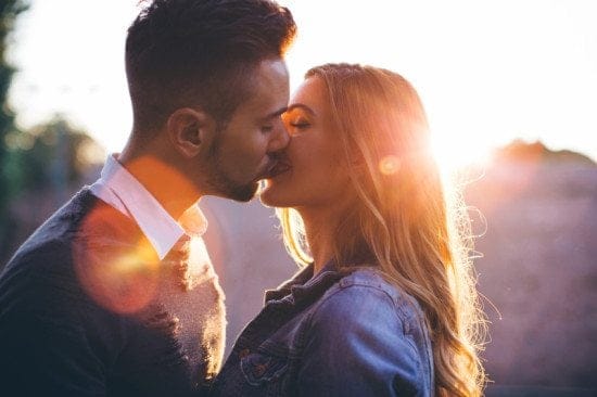 couple kissing at sunset