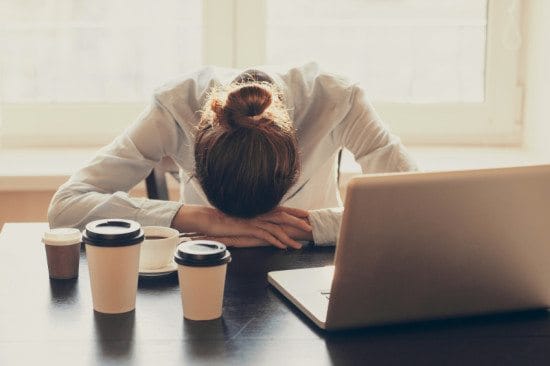 exhausted female office worker with head down